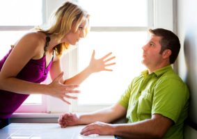 Woman pointing finger at man and yelling.